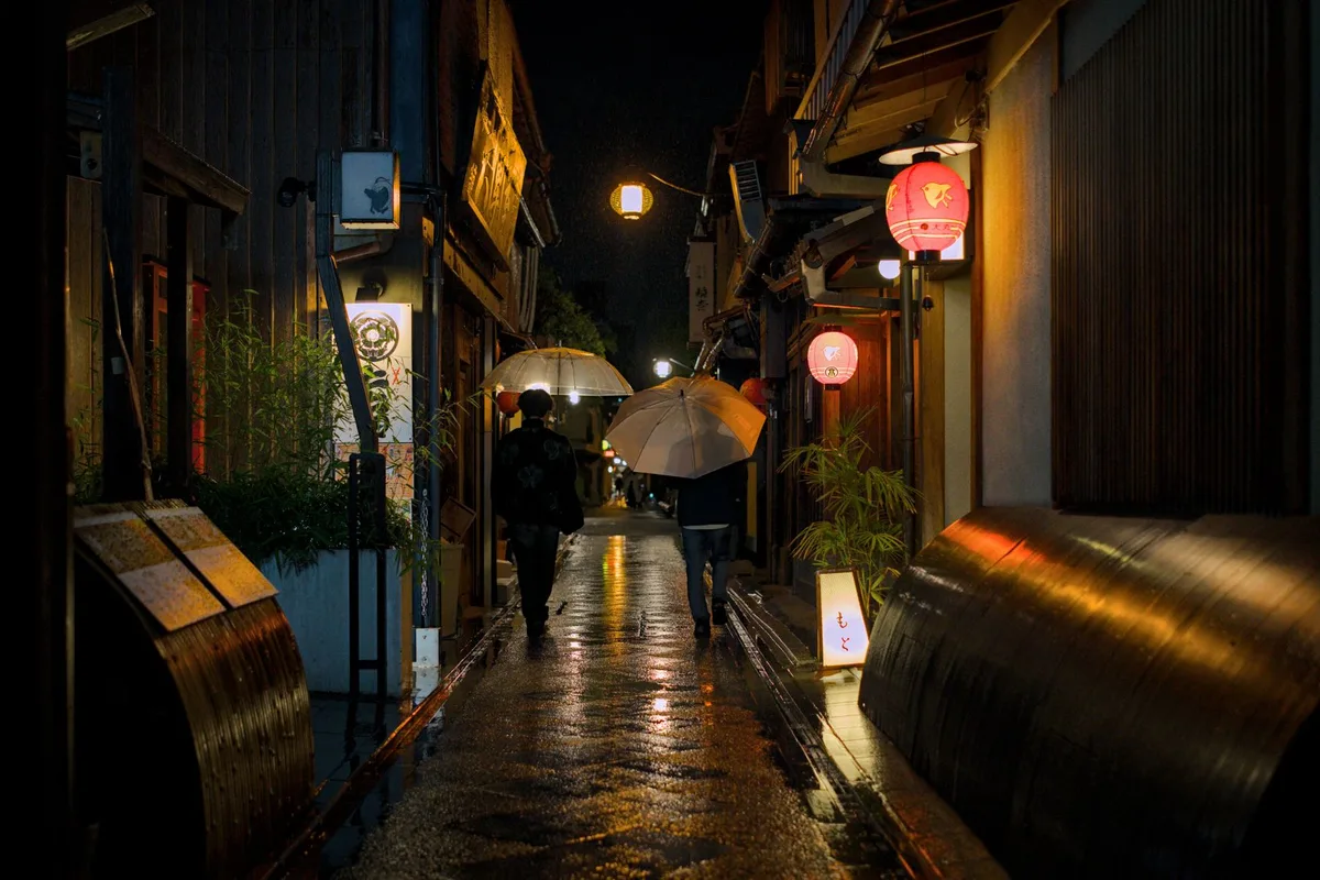 Die schmale, laternenbeleuchtete Gasse von Pontocho bei Nacht in Kyoto